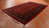 A very rich red hand knotted Bokhara rug will brighten even the darkest room
